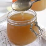 pour organic beef bone broth with a spoon back into the jar.