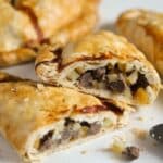 beef pasties cut in the middle to show the beef and potato filling inside.