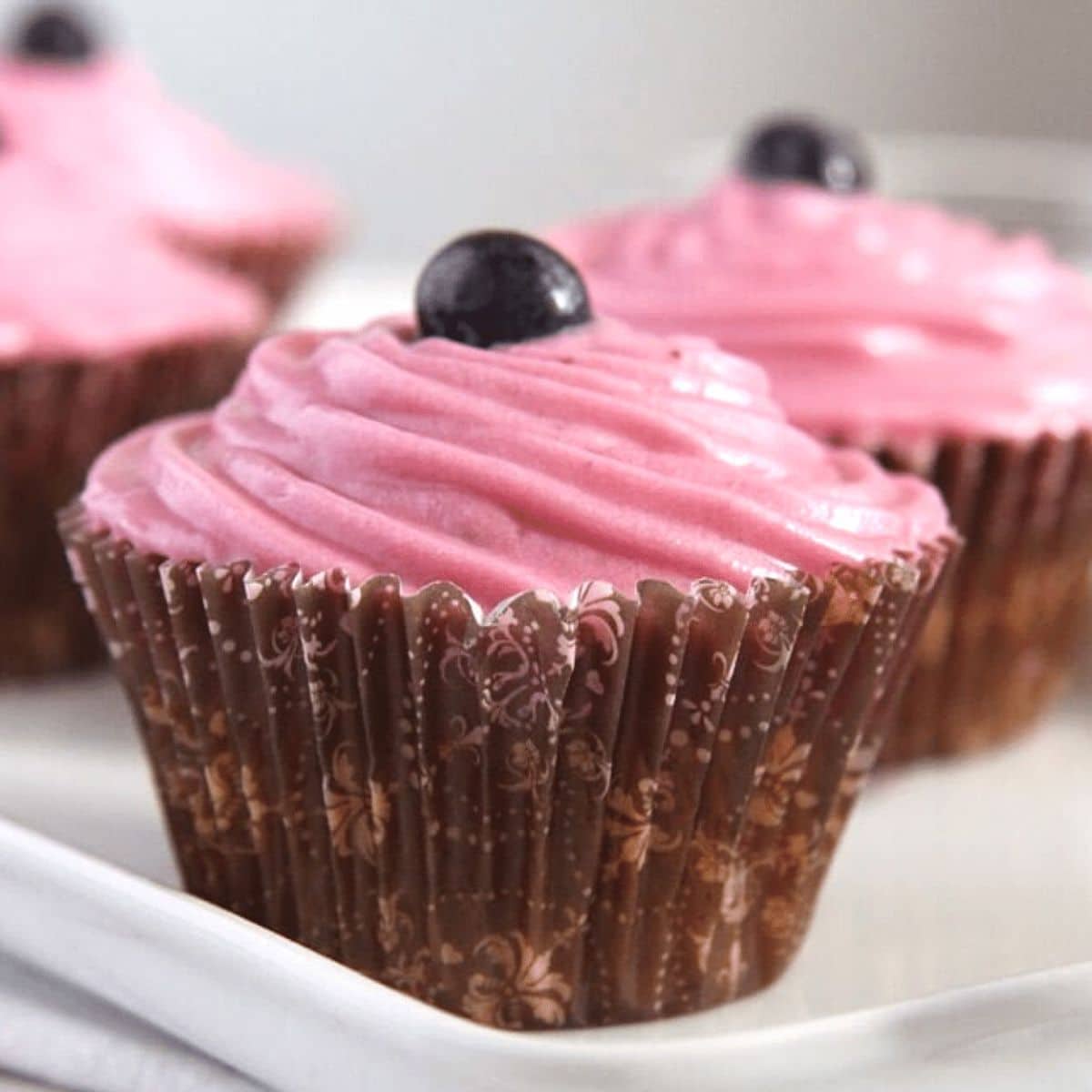 carrot cake muffins topped with blueberry frosting.