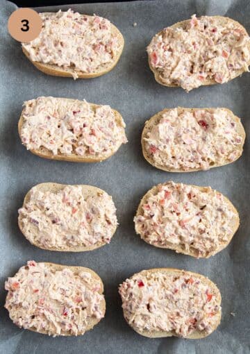 ham and cheese topped rolls before baking on a baking sheet.