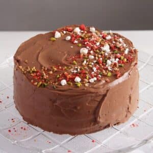 chocolate gateau with ganache on a cake plate.