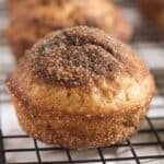 one cinnamon donut muffin on a wire rack, close up.