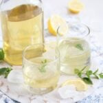elderflower liquor with lemons in bottle and glasses