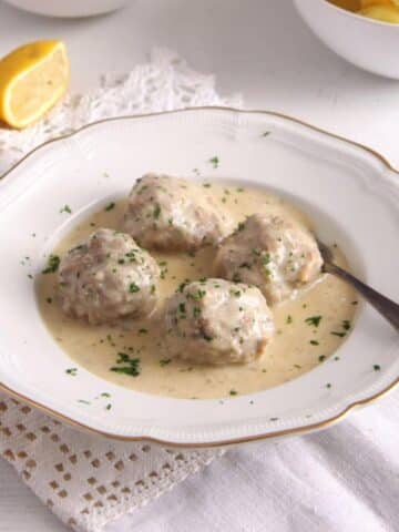 german meatballs with caper sauce served in a vintage deep plate.