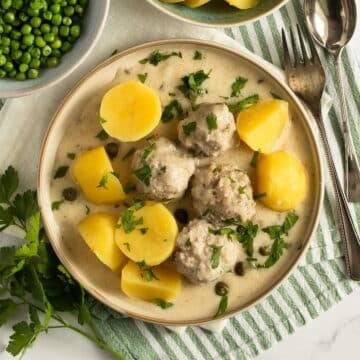 königsberger klopse or german meatballs in caper sauce served with boiled potatoes.