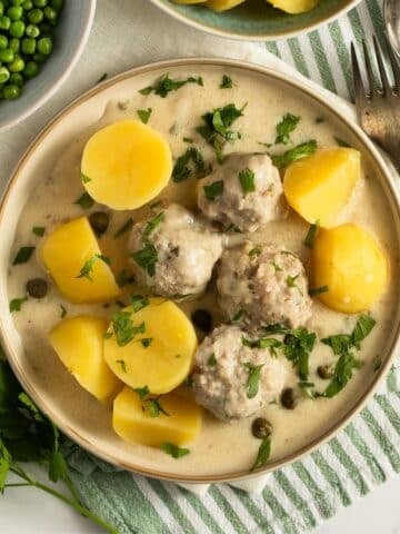 kรถnigsberger klopse or german meatballs in caper sauce served with boiled potatoes.