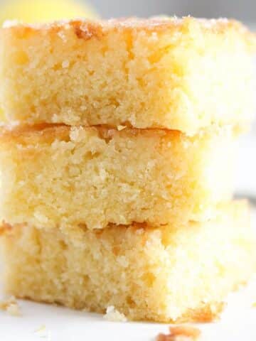three pieces of lemon drizzle traybake cake stapled on each other.