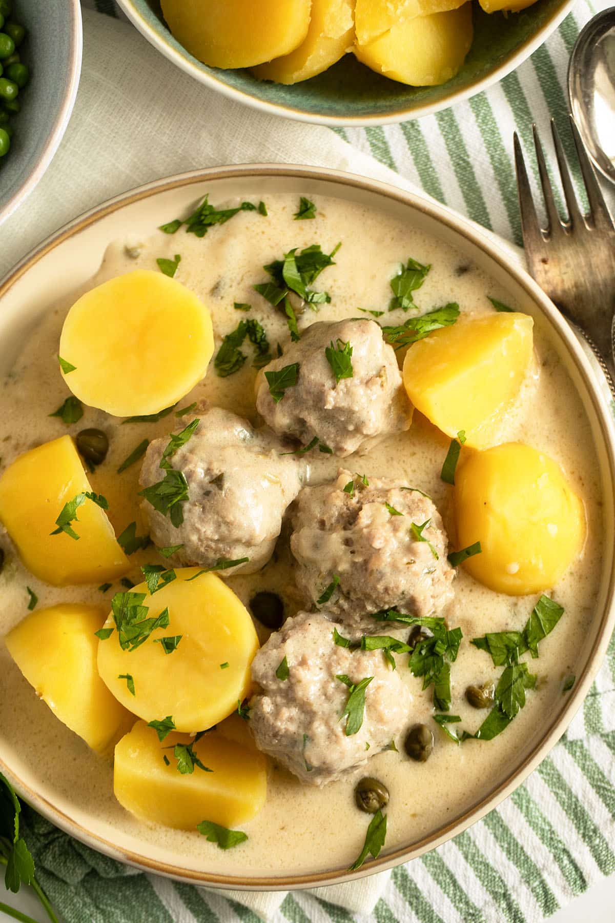 german meatballs in white caper sauce served with boiled potatoes.