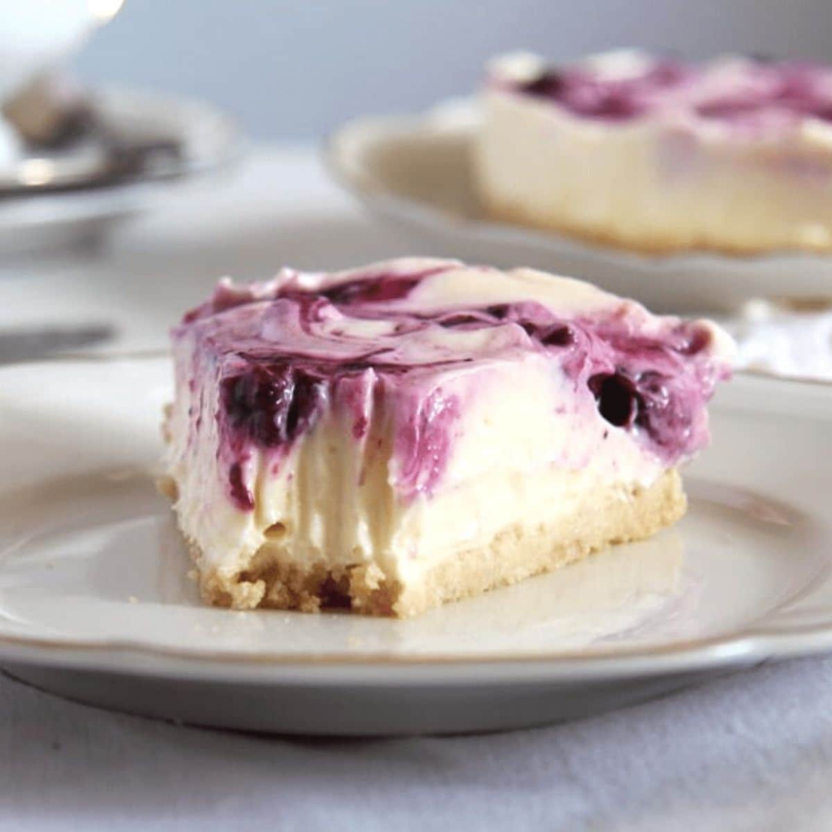 a slice of creamy no bake lemon curd cheesecake with fork marks at the top of the slice.