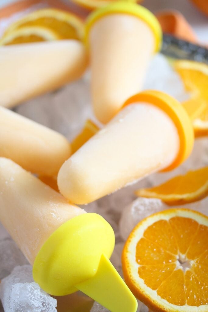 ice pops, oranges slices and ice cubes on a silver platter