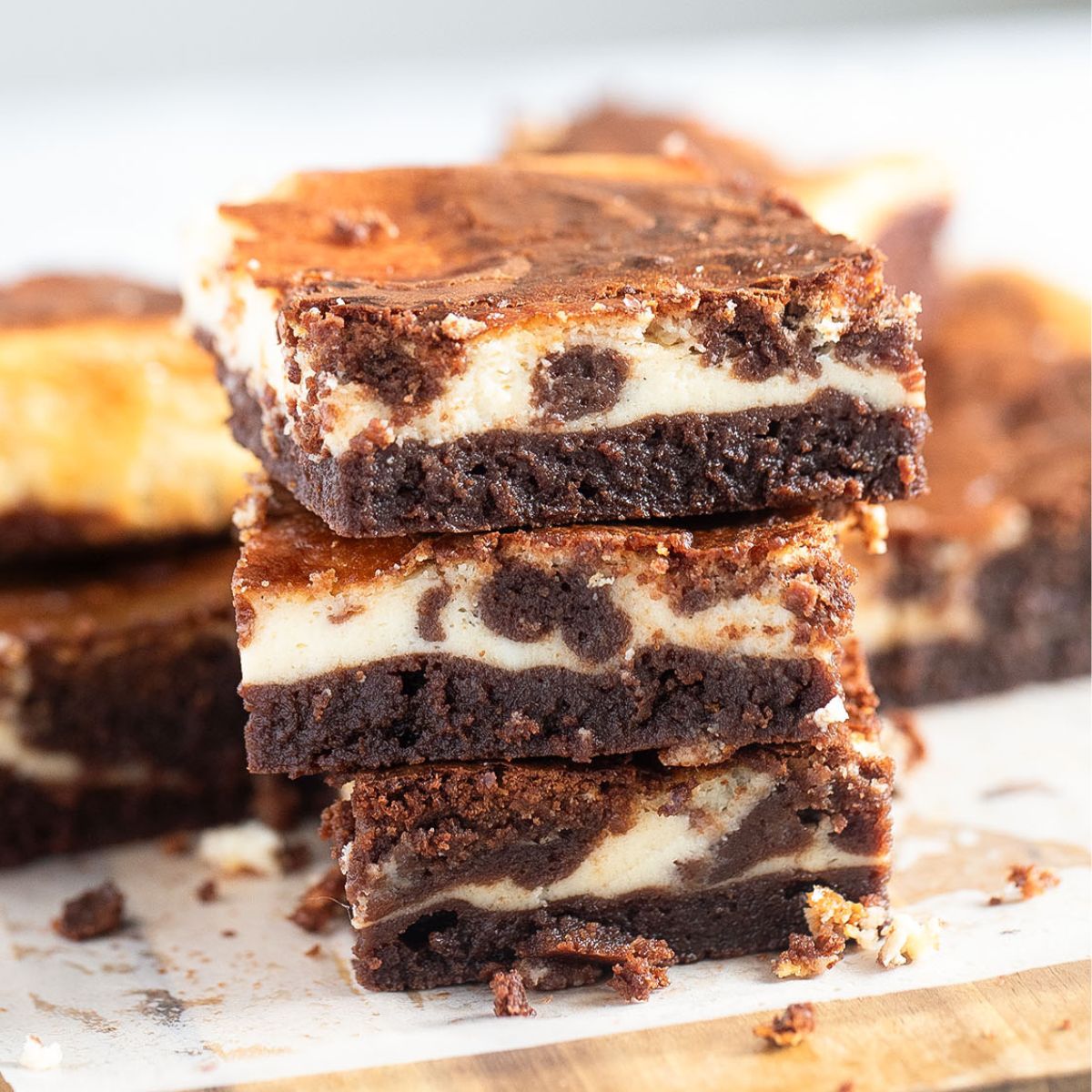 three stapled philadelphia cream cheese brownies on a cutting board.