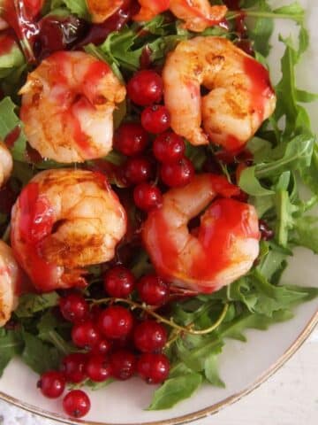 close up of prawn salad with red currants and arugula.
