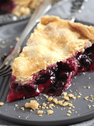 slice of rhubarb blueberry pie on a gray plate with a fork
