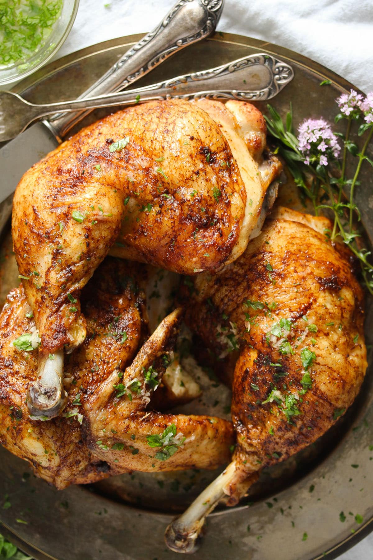 roasted half chicken, fork and knife on an old platter.