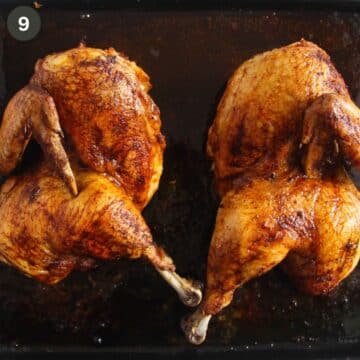 two roasted chicken halves on a baking tray.