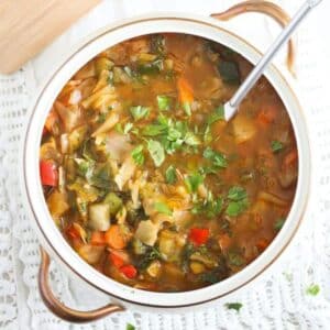 spanish vegetable soup sprinkled with parsley in a vintage serving soup bowl.