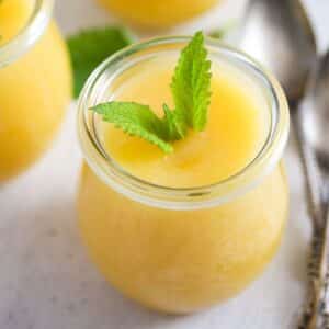 thermomix lemon curd garnished with mint leaves in a small jar.