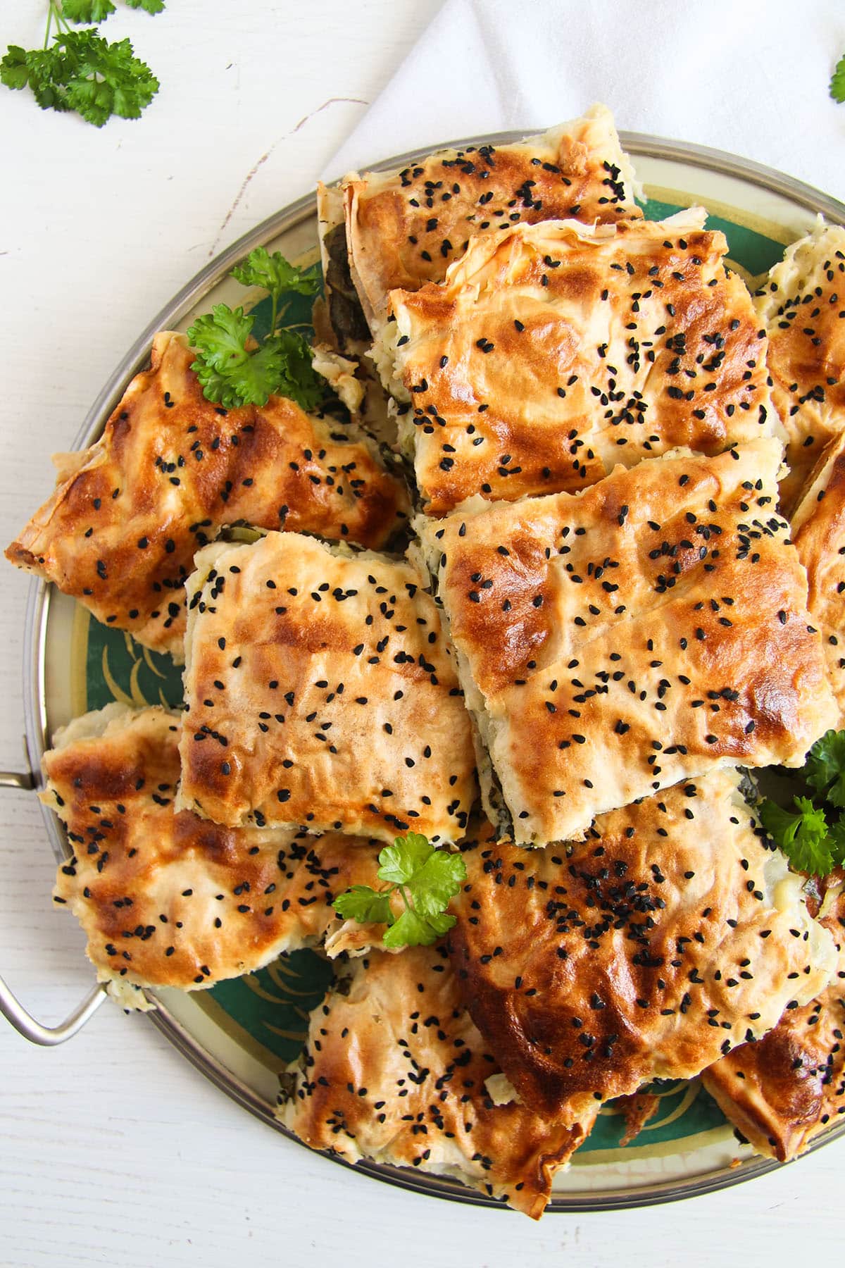 many pieces of spinach borek on a platter.