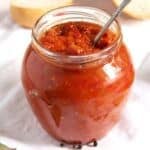 zacusca recipe or romanian eggplant spread in a jar with a spoon in it.