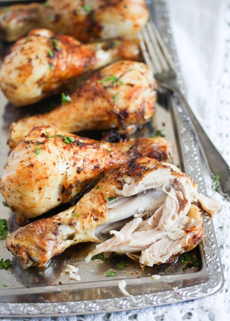 air fried drumsticks on a silver platter with a fork