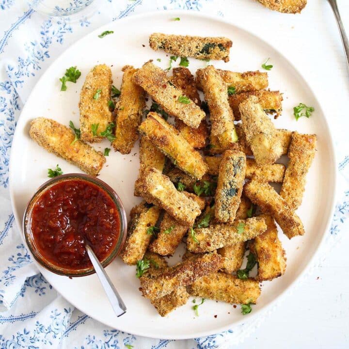 white plate with air fryer zucchini with chili dip