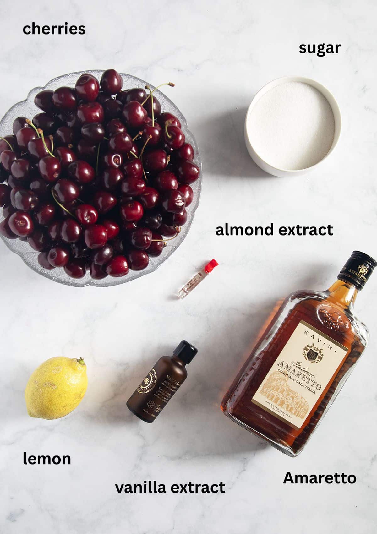 listed ingredients for canning cherries with amaretto, vanilla, almond extract, sugar and lemon.