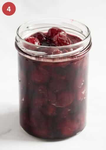 filling a jar with cherries and amaretto.