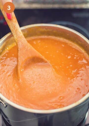 stir smooth apricot jam with a wooden spoon in a large pot.