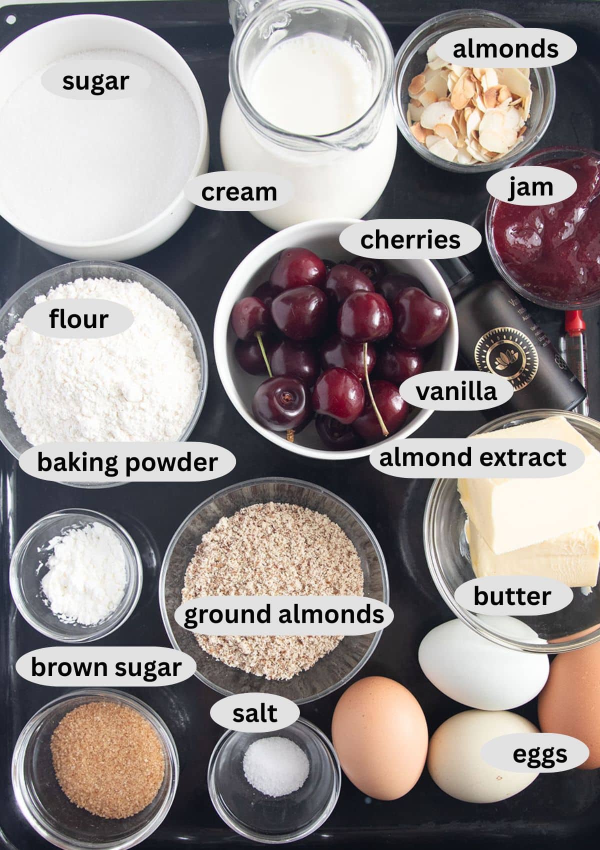 labeled ingredients for making bakewell cake with cherries, almonds and cream.