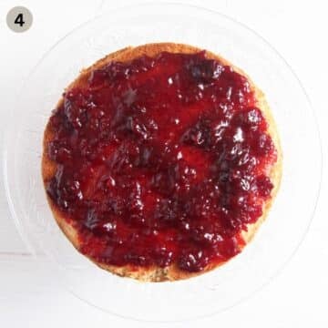 spreading jam on bakewell sponge cake.