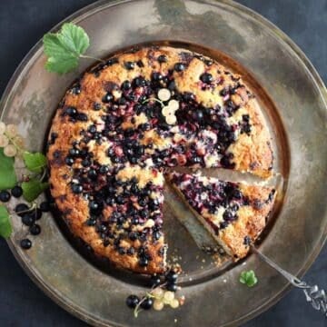 black currant cake with a leaf on a vintage black and black kitchen towel.