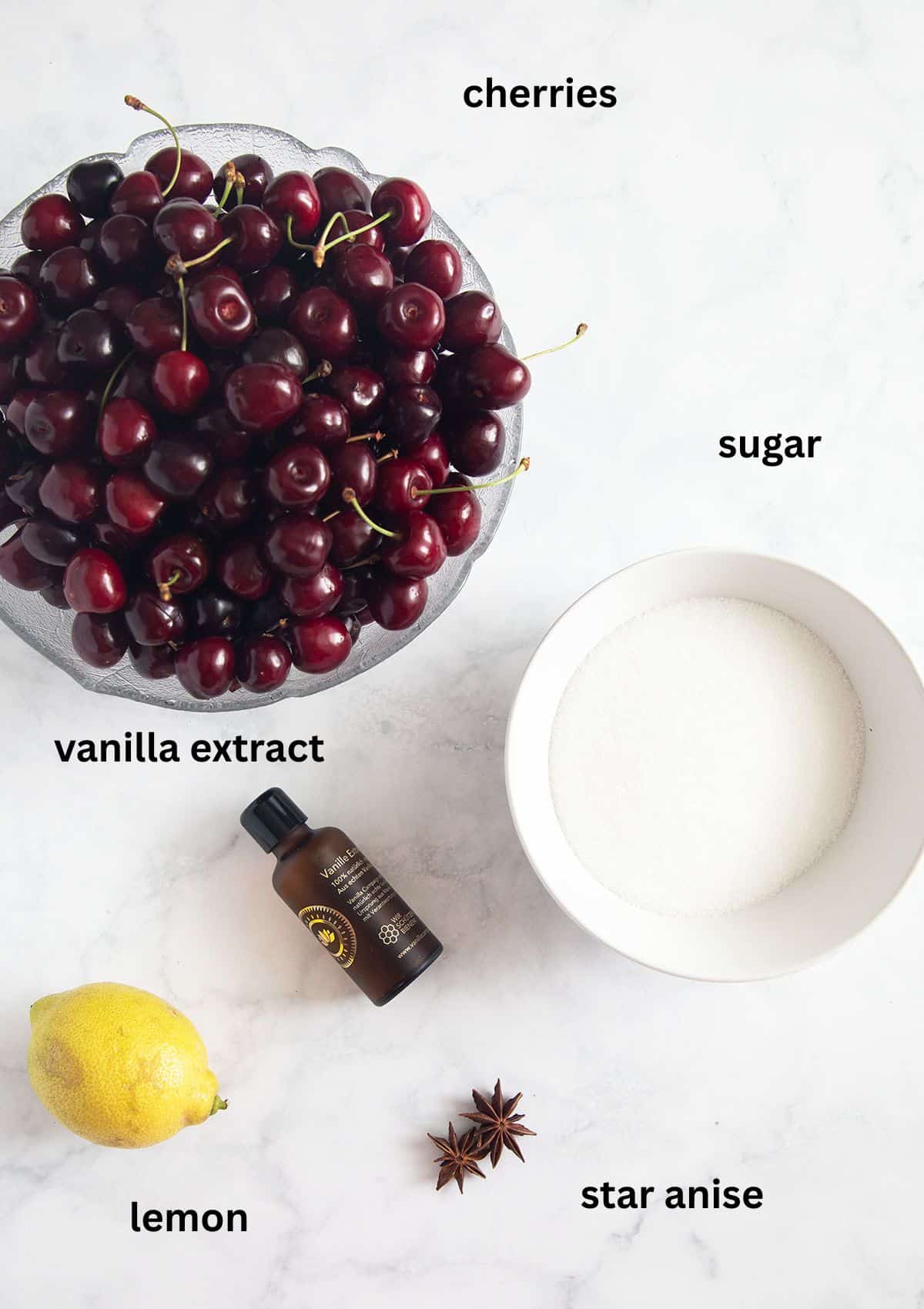 labeled ingredients for making candied cherries with sugar, lemon, vanilla extract, and star anise.