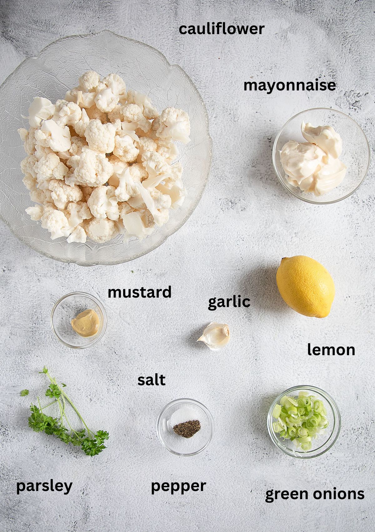 labeled ingredients for making cauliflower salad with mayo on the table.