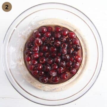 cherries marinating in a large bowl with sugar and spices.