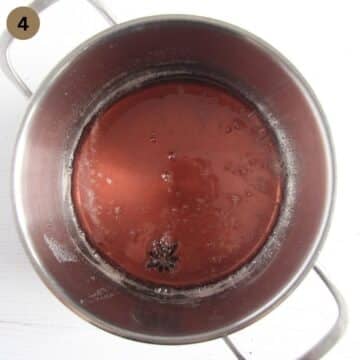 syrup and a star anise cooking in a large pot.