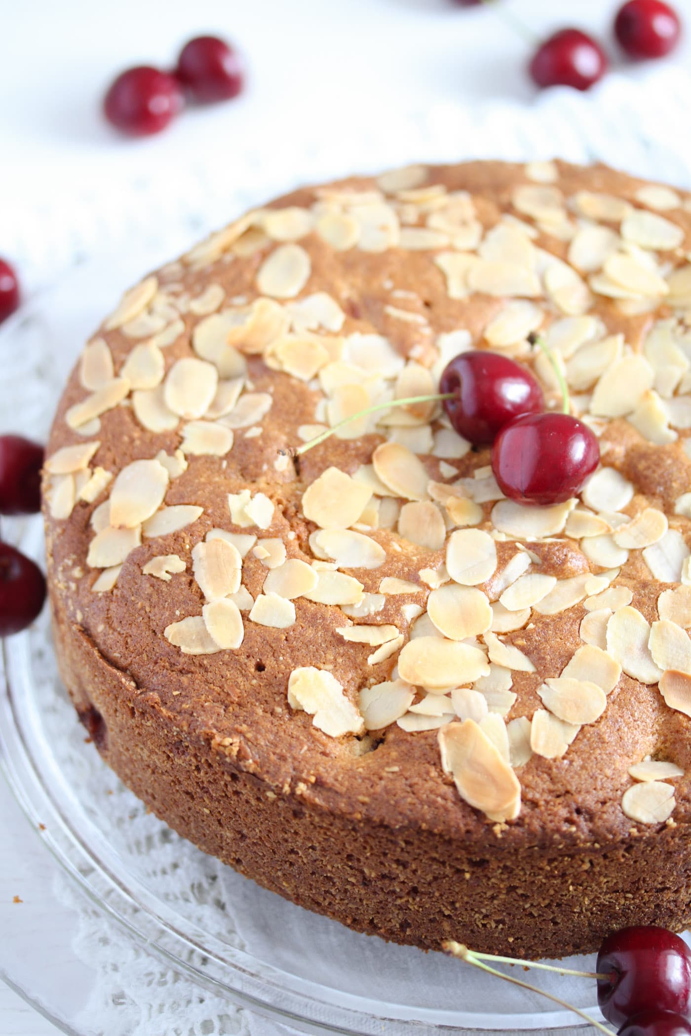 ground almond cake with fresh cherries on a platter