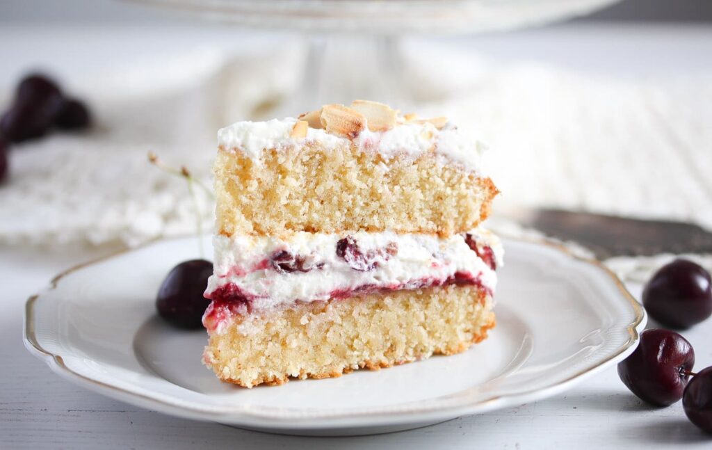 slice of cherry bakewell cake on a vintage platter