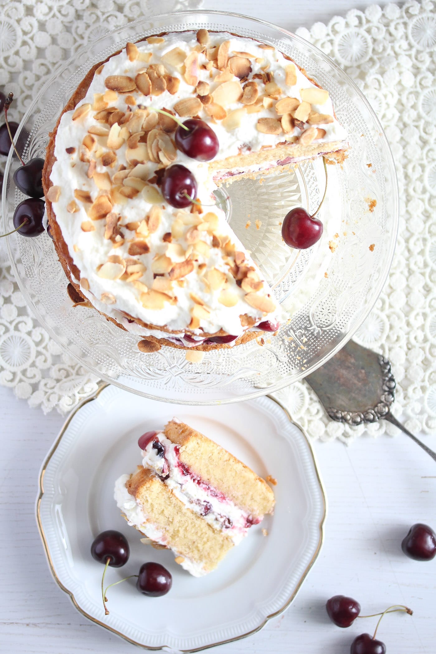 torte topped with toasted almonds and fresh cherries seen from above