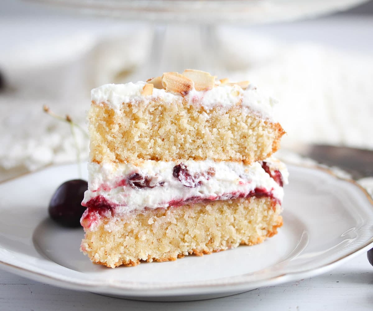 a slice of cherry bakewell cake on a small plate.