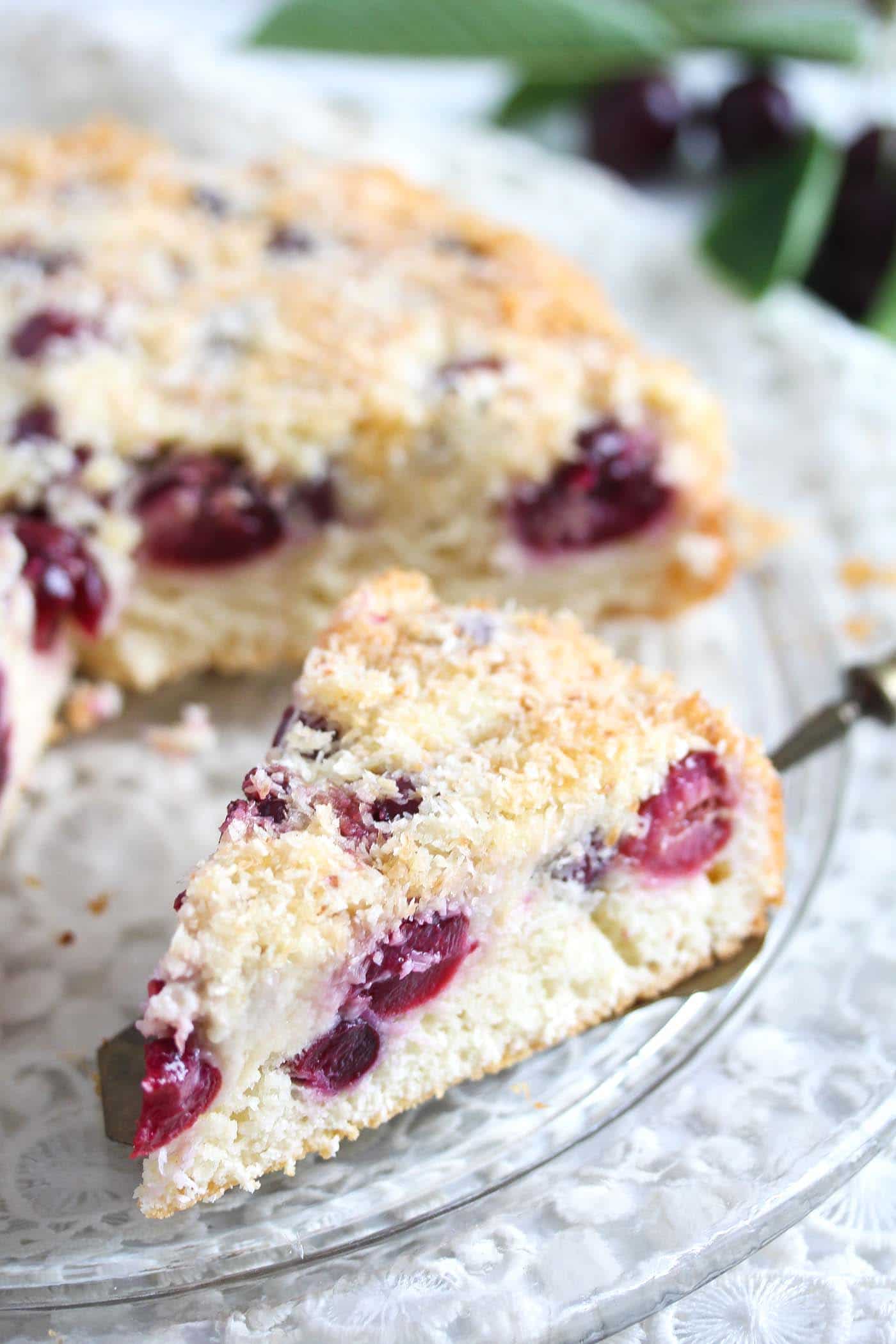 coconut and cherry cake sliced on a platter