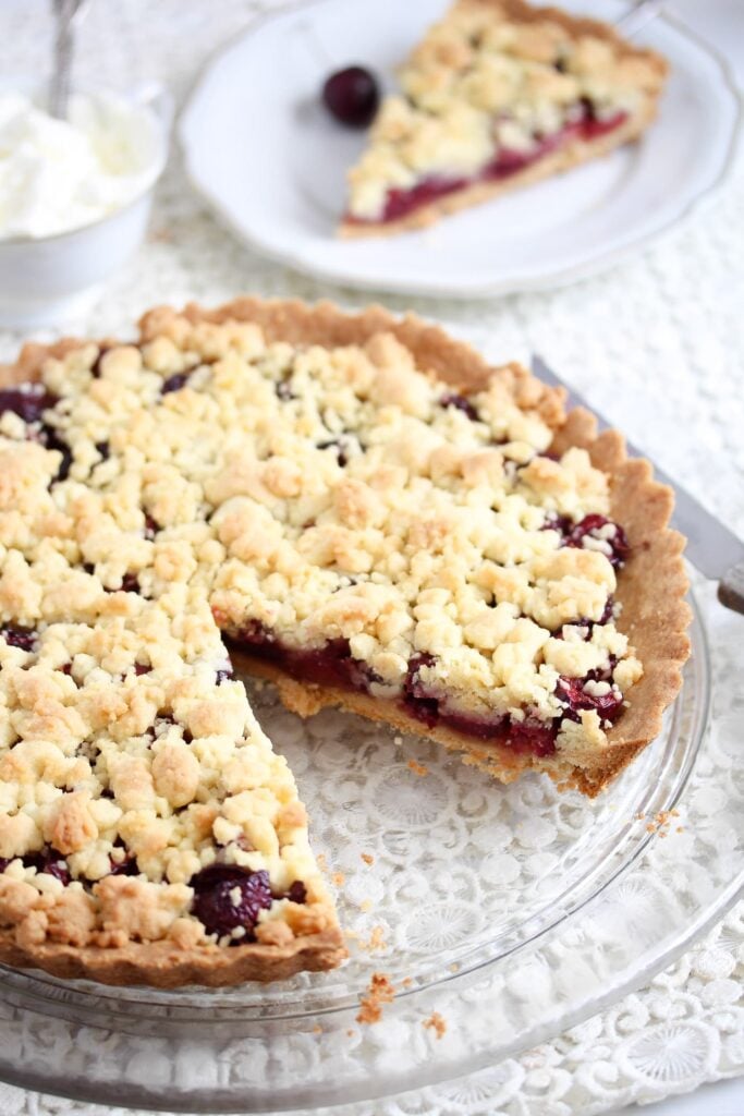 cherry crumb pie sliced on a platter