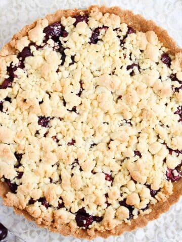 cherry crumb pie with golden topping on the table