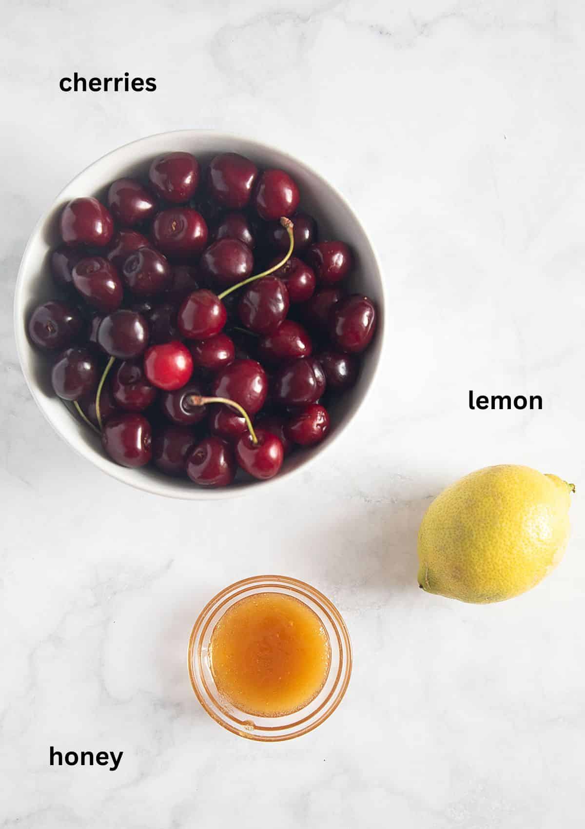 labeled ingredients for making cherry popsicles with honey and lemon.