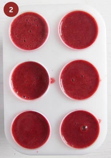 popsicle molds filled with cherry mixture.