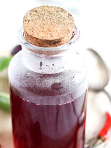 bottle of infused cherry vinegar with a cork lid