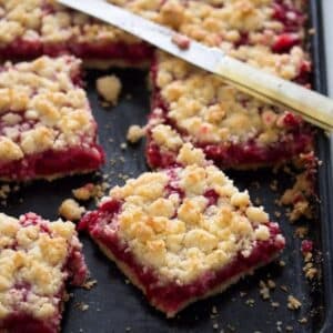 german red currant cake squares and a small knife.