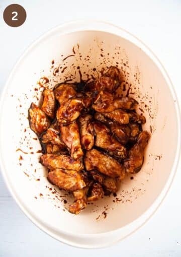 coated wings in hoisin sauce in a large mixing bowl.