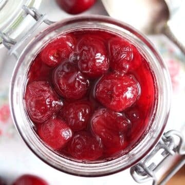 jar of cherries in kirsch, shiny and sweet.