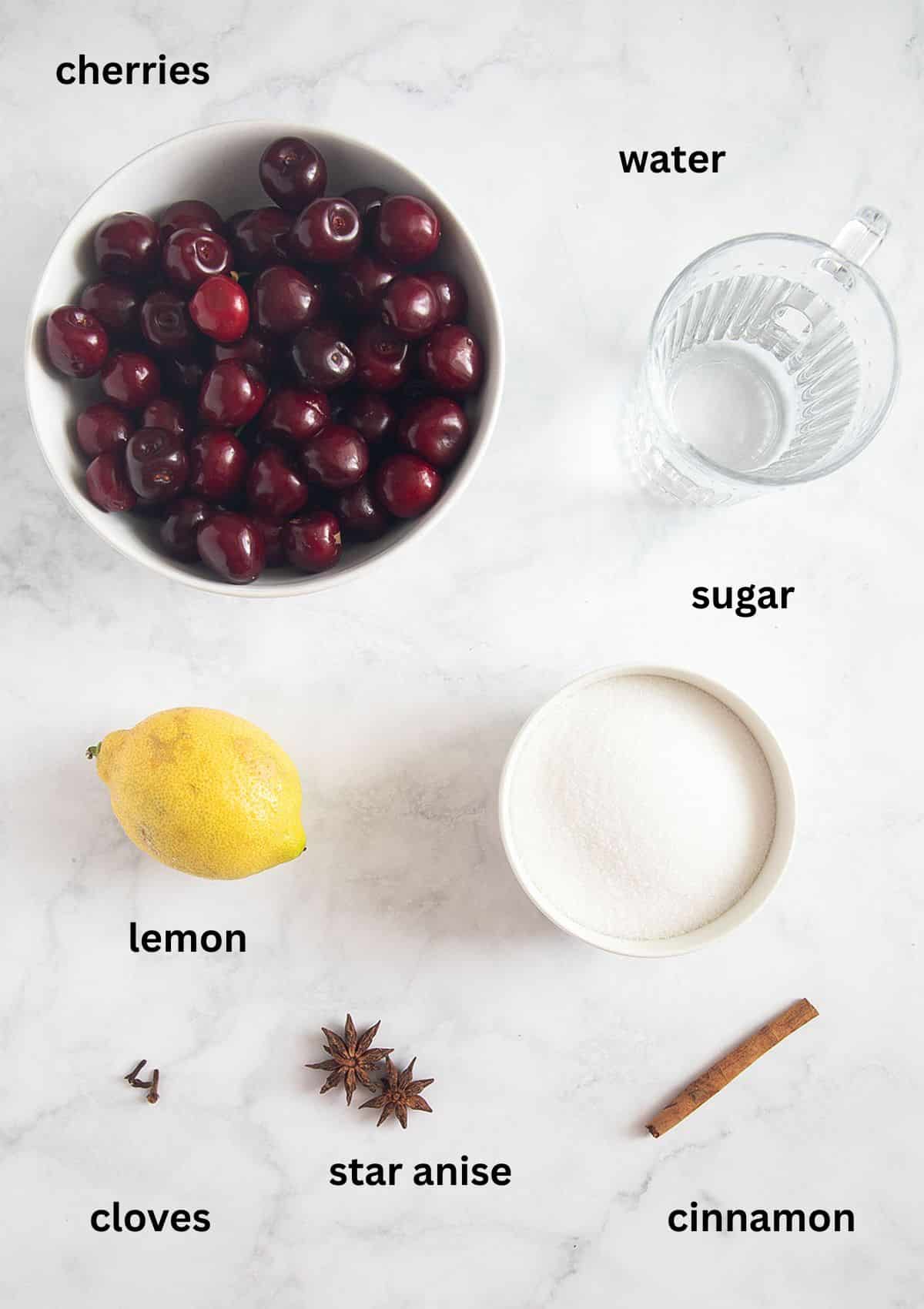 labeled ingredients for making cherries with kirsch, lemon, cinnamon, cloves, and star anise.