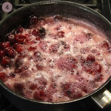 bubbling cherries in syrup cooking in a saucepan.